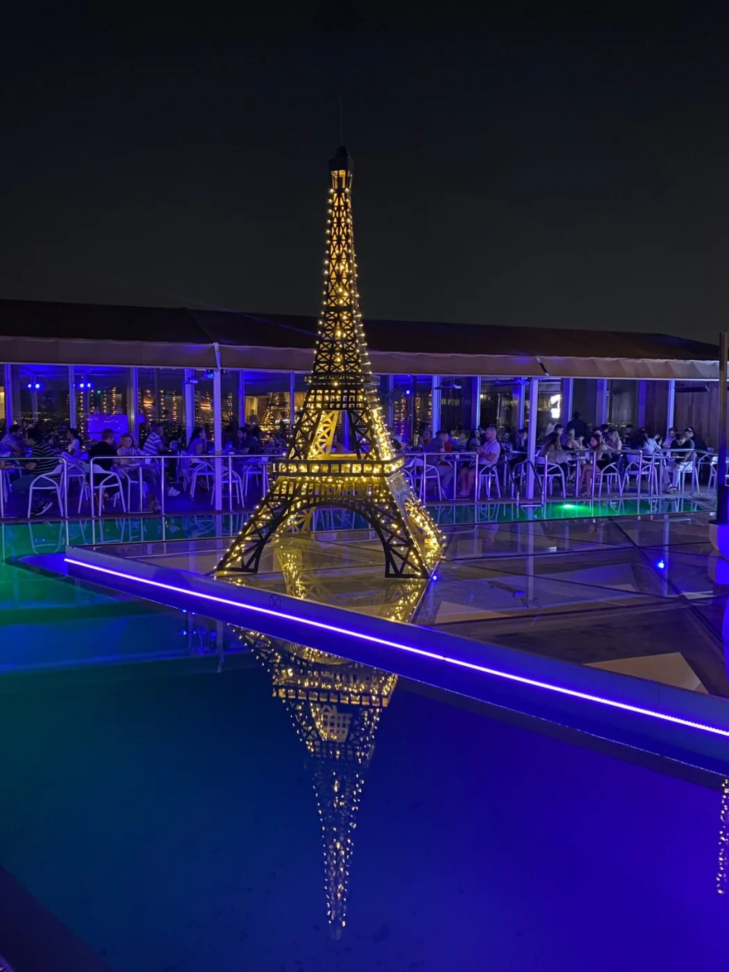 Torre Eiffel iluminada en piscina nocturna